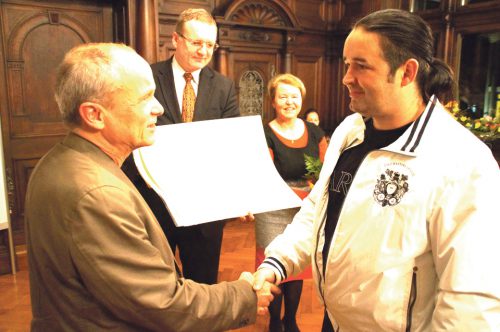 Architekt Dietmar Eichelmann, Jurychef, überreicht die Urkunde an Bauherr Heiko Symnick. Im Bild hinten: Ortsamtsleiterin Irina Brauner und Dresdens Ordnungsbürgermeister Detlef Sittel. Foto: Steffen Dietrich