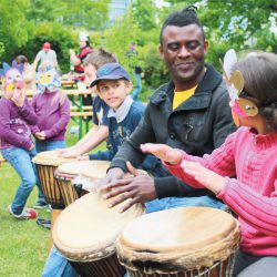 Trommeln macht Spaß, vor allem wenn Jack Panzo (Bildmitte) den Rhythmus vorgibt. Der aus Angola stammende Künstler war am 6. Mai Gast beim Frühlingsfest im Bürgergarten am Koitschgraben der gleichnamigen Kontaktstelle in Strehlen. Foto: Stadtteilbüro am Koitschgraben