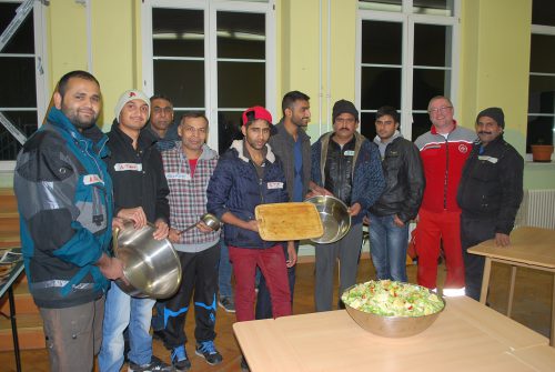 Bewohner der Notunterkunft Schleiermacherstraße mit Unterkunftsleiter Carsten Stephan (2.v.r.). An diesem Tag fand eine Kochaktion mit den Initiatoren von »cooking actions« statt, deren Konzept es ist, mit Flüchtlingen gemeinsam zu kochen. Foto: Claudia Trache