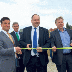 Oberbürgermeister Dirk Hilbert beim symbolischen Akt. Gemeinsam mit Investor Holm Claußnitzer (l.) und Jörg Drews vom Bauunternehmen Hentschke Bau zerschneidet er das Band auf der Brücke über den Flössergraben. Foto: Möller