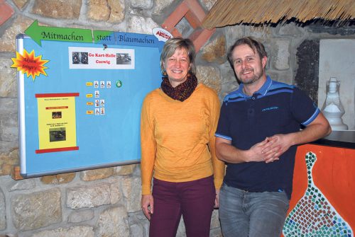 die beiden Sozialpädagogen Carmen Pelzer (l.) und Silvio Schmidt vor der Aktionstafel im Café der Schieferburg. Carmen Pelzer ist von Anfang an im KJH tätig. Es wurde am 6. Dezember 1996 eröffnet. Foto: Trache