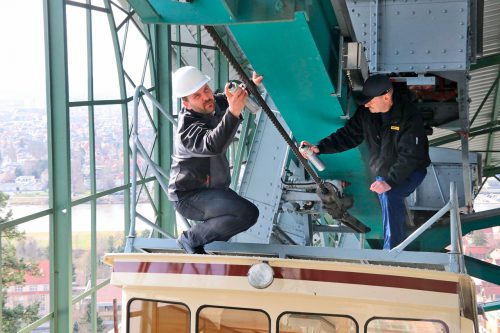 Michael Kronschnabel (l.), Vertriebsleiter Seilschmierstoffe Elaskon, und Carsten Lauterbach von den Bergbahnen behandeln das Drahtseil mit Schmierstoff. Foto: Zänker