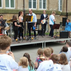 Zum Sommerfest in der 25. Grundschule spielte die Schülerband der Oberschule. Als Moderator konnte Sportkommentator Marc Huster (mitte) gewonnen werden, der in seiner aktiven Zeit als Gewichtheber Europa- und Weltmeistertitel gewann. Foto: Pohl