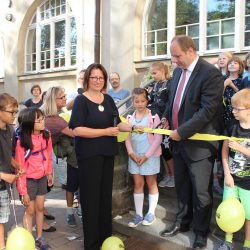 Anlässlich der eröffnung des Tolkewitzer Gymnasiums durchschneidet Oberbürgermeister Dirk Hilbert das Band am hinteren Eingang der Sieben-Schwaben-Schule. Die Schulleiterin Dr. Ulrike Böhm assistiert ihm, Grundschüler und Gymnasiasten schauen aufmerksam zu. Foto: Pohl