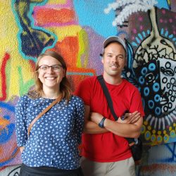 Die beiden Organisatoren Yvonne Bonfert und Jens Besser vor einer von Kindern gestalteten Wand. Foto: Trache