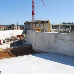 Verschiedene Gewerke geben sich auf der Baustelle des neuen Einkaufs- und Dienstleistungszentrums in Zschachwitz die Klinke in die Hand. Ende September soll bereits der Rohbau fertig sein. Im Bild: die Auffahrrampe zum Parkdeck. Foto: Trache