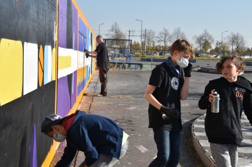 Schülerinnen und Schüler der 9. Grundschule waren nach dem Unterricht mit großem Spaß dabei, dem Riesengraffiti den letzten Schliff zu verpassen. Foto: Möller