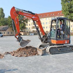 Sportbürgermeister Peter Lames vollzog den ersten Baggerhub für den neuen Kunstrasenplatz, unterstützt von Uwe Sacklowski, Geschäftsführer der Firma Sport- & Freianlagenbau, die das Vorhaben umsetzt. Foto: Pohl