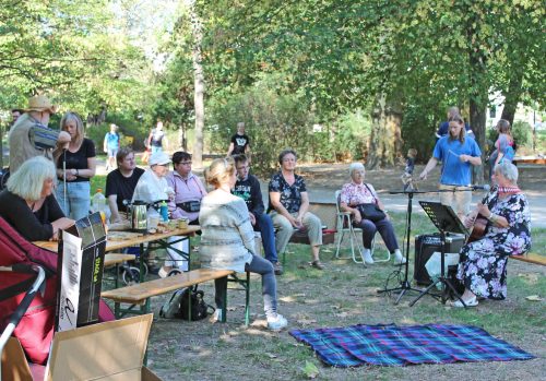 Annelie Mildner, die singende ehemalige Krankenschwester, erfreute die Besucher mit Liedern zur Gitarre im Rothermundtpark. Foto: Pohl