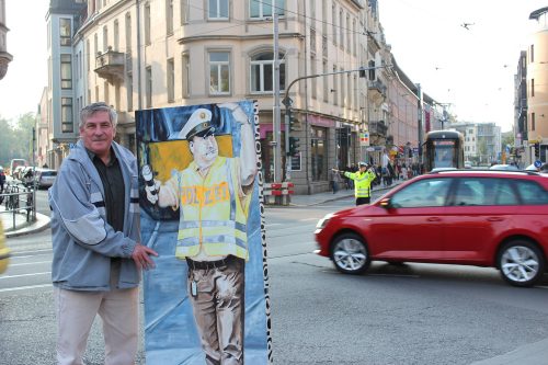 Günther Jakob dirigierte jahrelang am Schillerplatz den Verkehr. Daran erinnert ein lebensgroßes Bild. Am 26. Oktober 2018 kehrte der Ruheständler noch einmal an den Ort des Geschehens zurück, denn sein Bild wurde an den Polizeipräsidenten Horst Kretzschmar übergeben. Es erhält nun einen würdigen Platz im Polizei-Museum. Für eine halbe Stunde übernahmen Polizeibeamte die Verkehrsregelung. Foto: Pohl