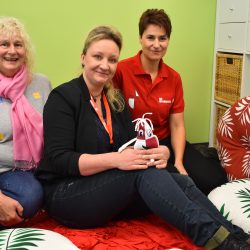 Eileen Hermus hält das Maskottchen Lacrimi in der Hand. Annedore Molly (l.) und Katja Schwensow (r.) gehören zum Team der ehrenamtlichen Helfer. Foto: Trache