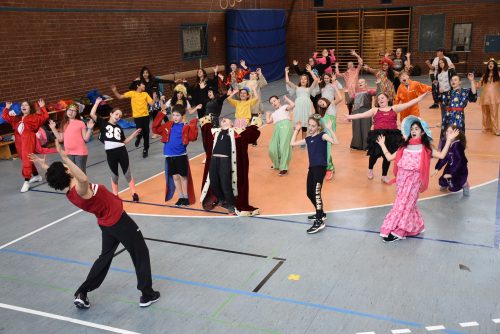 Choreografin Yeri Anarika Sanchez (vorn) zeigt Schülern der Klassen 5c und 6a die ersten Tanzschritte. Foto: Trache