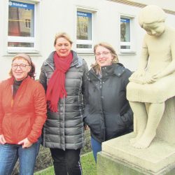 Bibliotheksleiterin Katrin Doll (Mitte) sowie ihre Mitarbeiterinnen Andrea Mockert (links) und Carolin Schneider hoffen, dass die Skulptur „Lesendes Mädchen“ von Heinz Mamat vom Nürnberger Ei zum Münchner Platz mit umzieht. Foto: Ralf Richter
