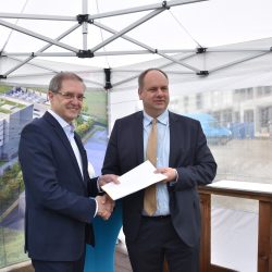 Ein weiterer Meilenstein: Oberbürgermeister Dirk Hilbert konnte Projektleiter Otto Graf die zweite Teilbaugenehmigung für die neue Halbleiterfabrik im Dresdner Norden übergeben. Foto: Möller