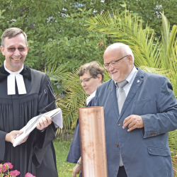 Rektor Stephan Siegmann und der Geschäftsführer der Evangelischen Behindertenhilfe Matthias Kühn (r.), die künftig das Hotel betreiben wird, füllen die Zeitkapsel mit aktuellen Dokumenten. Foto: Möller