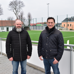 Jens Brochlitz (links) mit dem Vereinsvorsitzenden Roland Leubner vor dem neuen Kleinfeldkunstrasenplatz und Vereinsheim. Foto: Claudia Trache