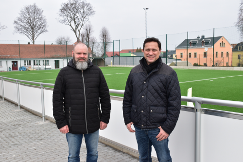 Jens Brochlitz (links) mit dem Vereinsvorsitzenden Roland Leubner vor dem neuen Kleinfeldkunstrasenplatz und Vereinsheim. Foto: Claudia Trache