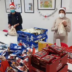 Ehrenamtliche bereiten die Weihnachtspäckchen vor. Foto: Malteser